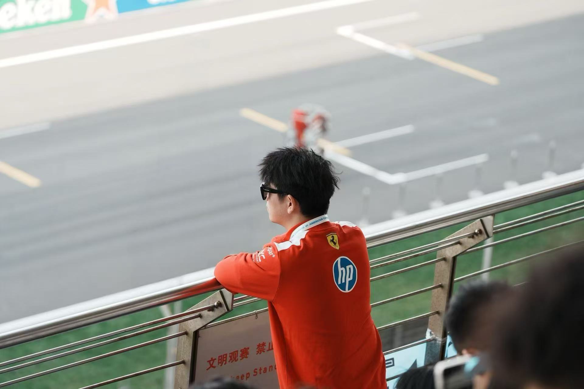 Ethan 身穿红色车队服，在赛道看台观赛
